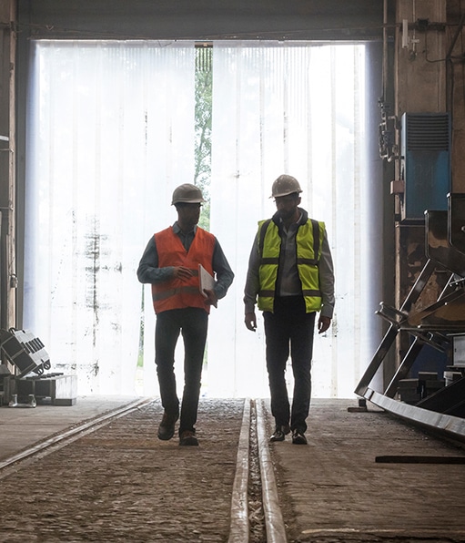 HazTek Inc. - Two safety managers engaged in a discussion while walking through a HazTek job site.